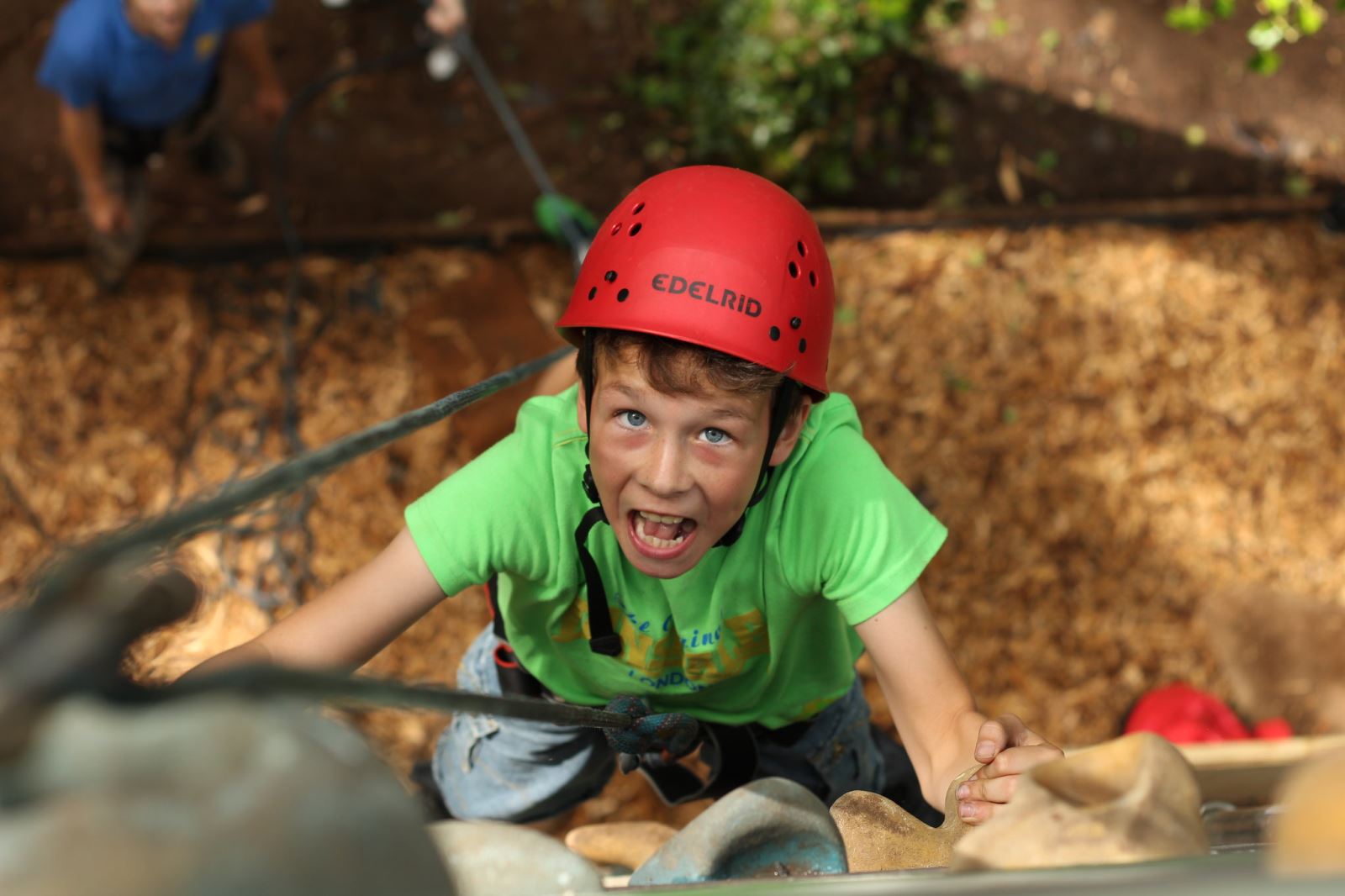 Child looking up as he rock climbs
